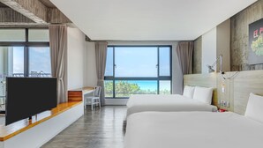 Habitación de hotel con una cama grande, un televisor sobre un mueble de madera, un escritorio con una silla y un ventanal con vistas.
