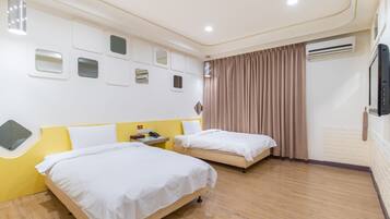 Een hotelkamer met twee bedden, een spiegel, een telefoon en een airconditioning.