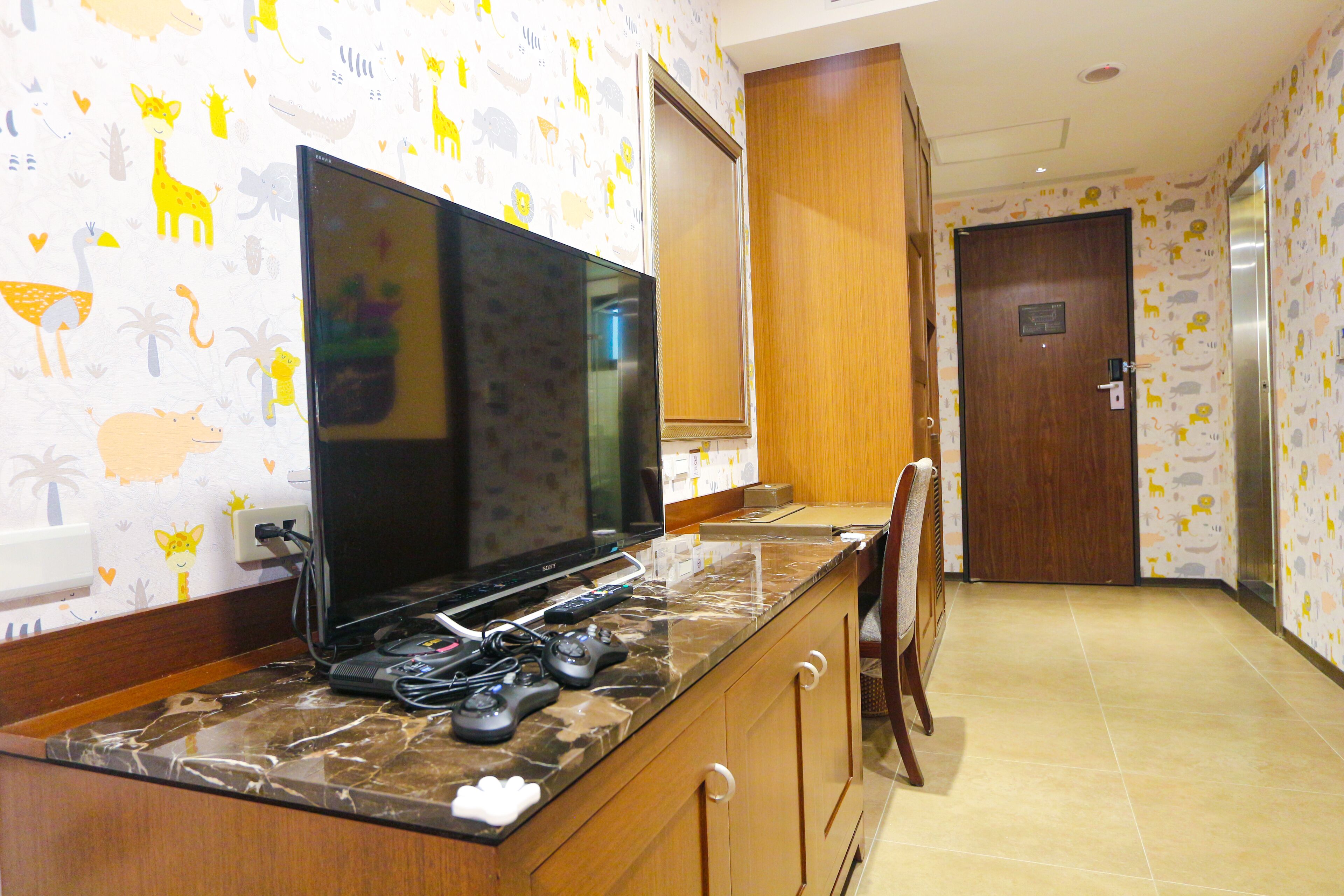 Una cocina con televisor de pantalla plana grande, encimera de mármol y armarios de madera.