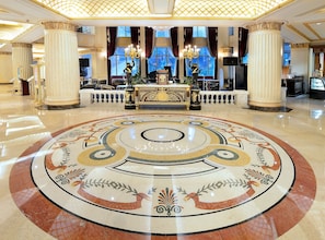 Experience the grandeur of our lobby, featuring a stunning chandelier, intricate mosaic floor, and elegant columns.