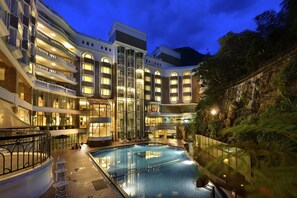 A multi-story hotel with a swimming pool, outdoor seating, and a waterfall feature. - The Chitou Lemidi Hotel (Lugu)