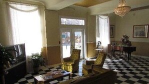 A checkered floor, a sofa, a chair, a table, and a chandelier.