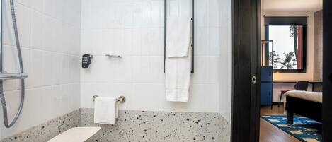 A bathroom with a shower, a towel rack, and a small shelf.