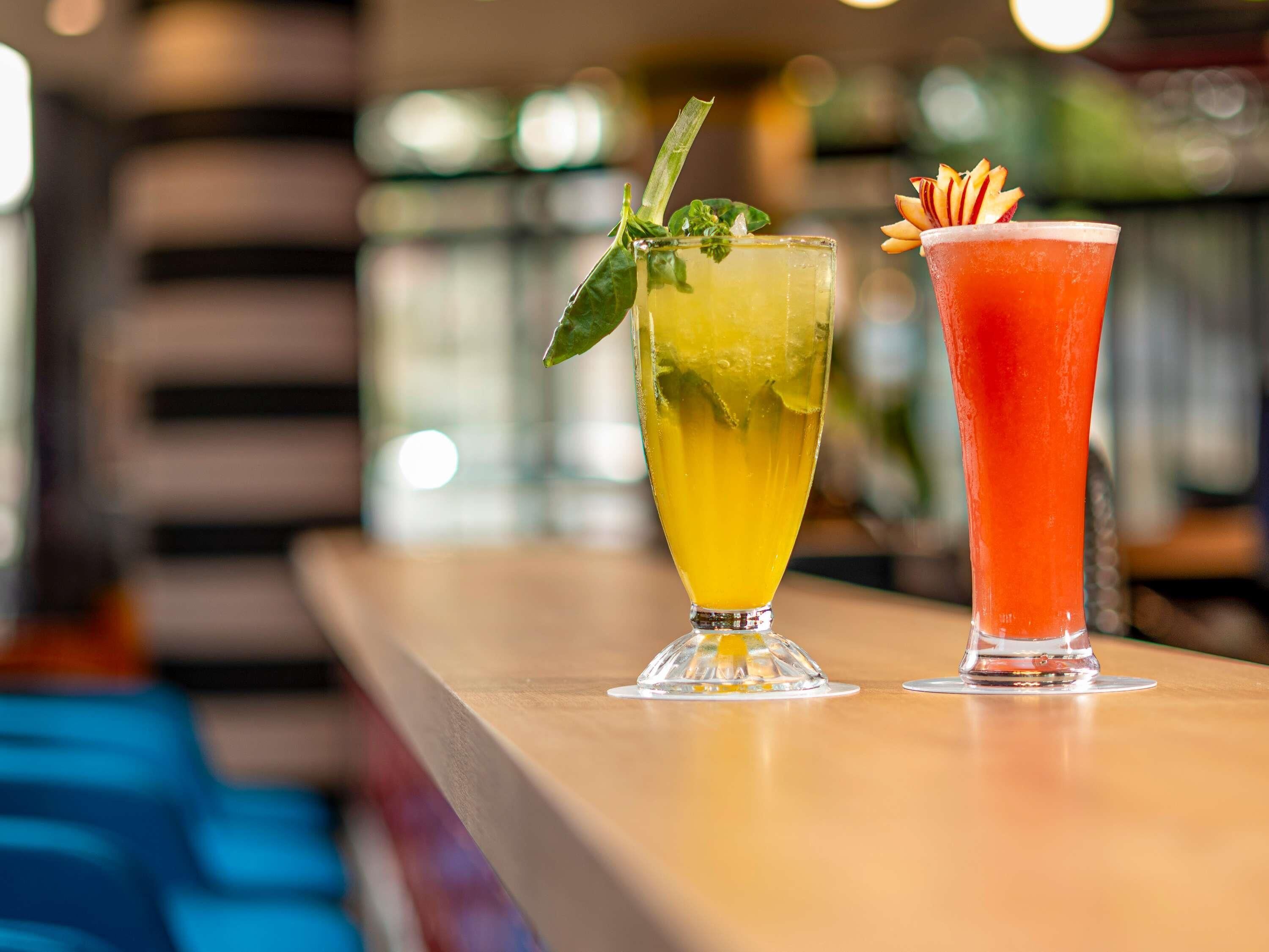 Two cocktails on a bar counter.