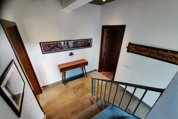 Una escalera con un escritorio de madera y un cuadro en la pared.