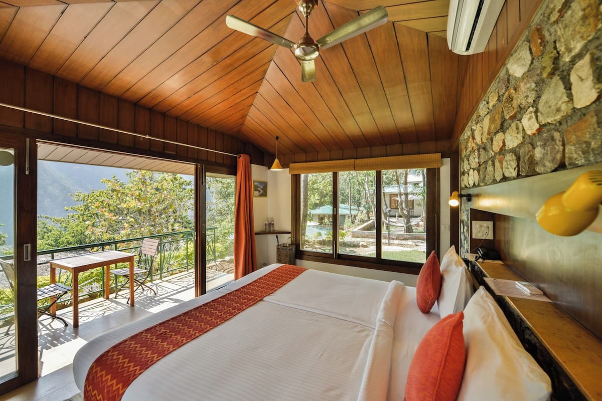 A spacious bedroom with a large bed, a ceiling fan, and a view of the outdoors.