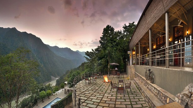A terrace with a fire, outdoor seating, and a view of a valley.