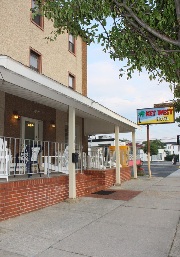 A hotel with a covered porch, brick facade, and a sign for Key West Hotel. - Key West Motel (Wildwood)