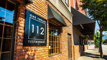 A brick building with a sign reading "One Twelve 112 Restaurant".