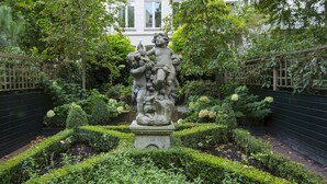 A garden with a central statue surrounded by manicured hedges and trees. - Dutch Masters Amsterdam (Amsterdam)