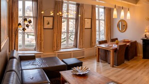 A modern living room with a sofa, a wooden coffee table, and a dining area with chairs and a table. - Dutch Masters Amsterdam (Amsterdam)