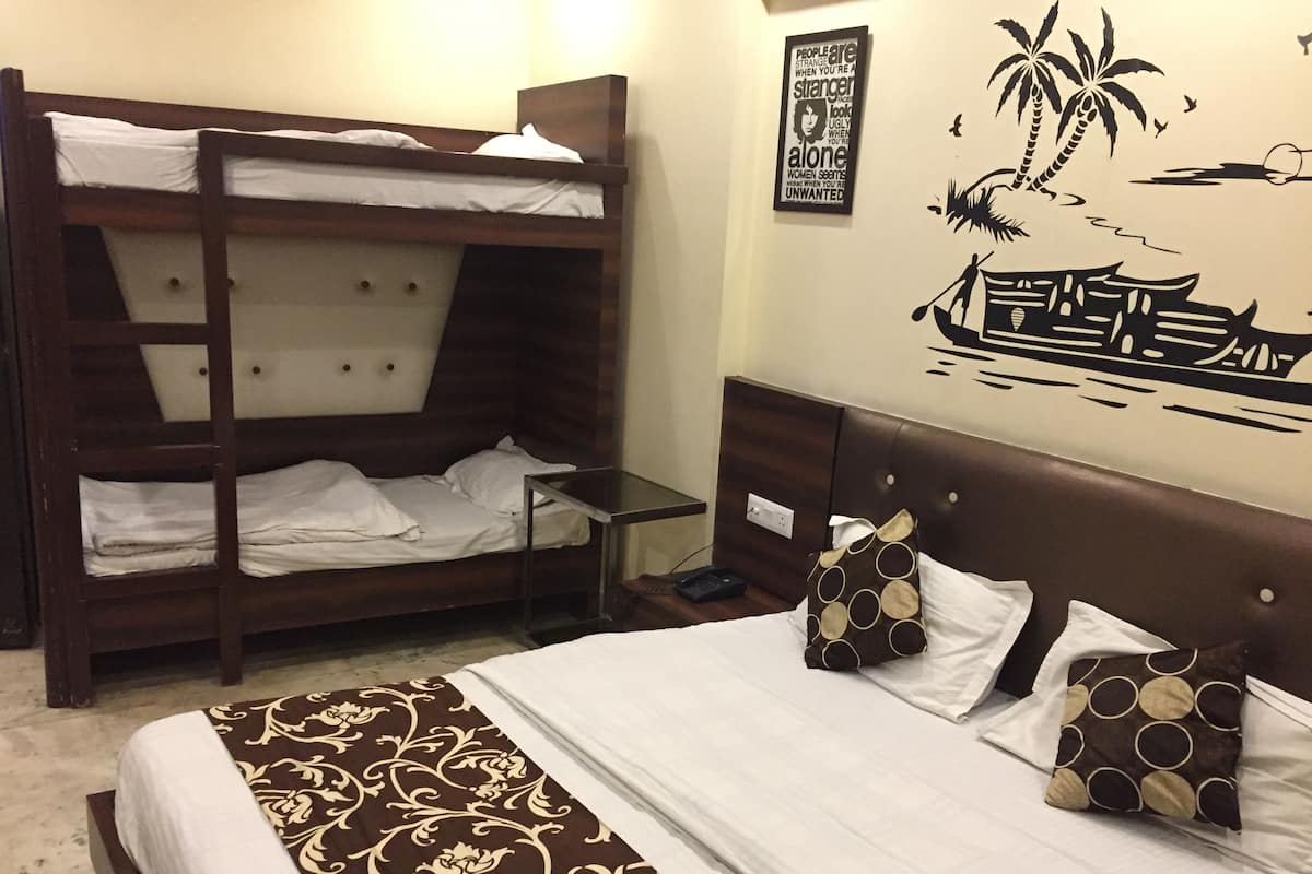 A room with a bunk bed, a single bed, and a wall mural.