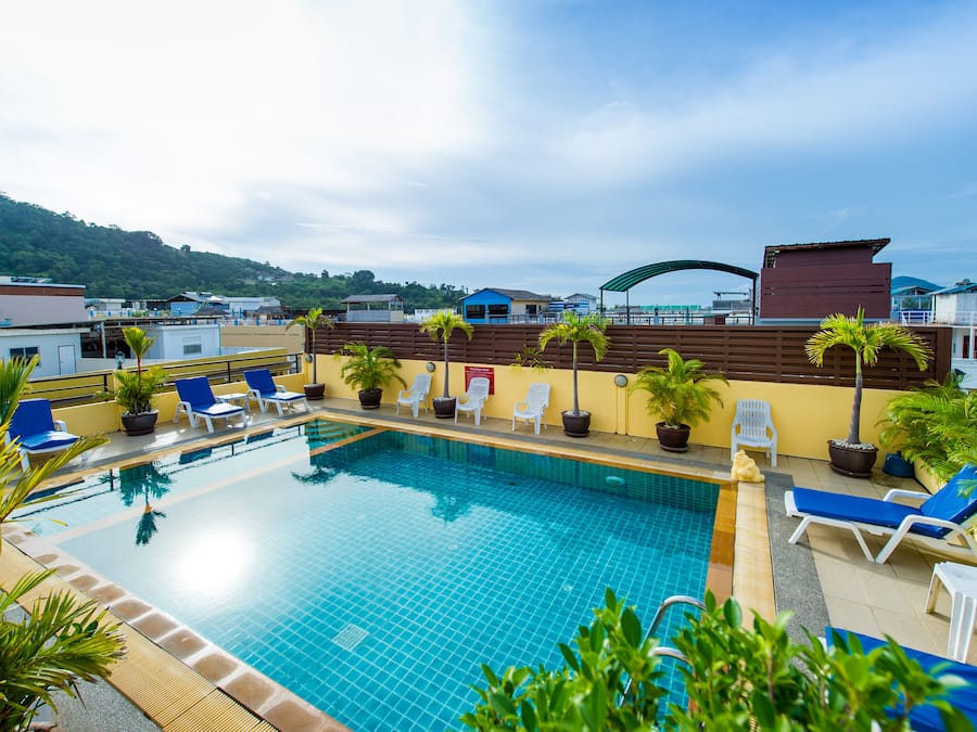 Una piscina al aire libre, sillones reclinables de piscina