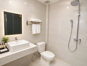 A modern bathroom with a white sink, toilet, and shower. - Victorian Nha Trang Hotel (Nha Trang)