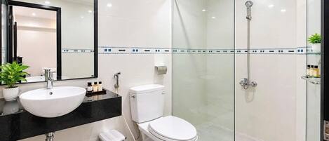 A modern bathroom with a glass-enclosed shower, a white toilet, and a sink with a black countertop.