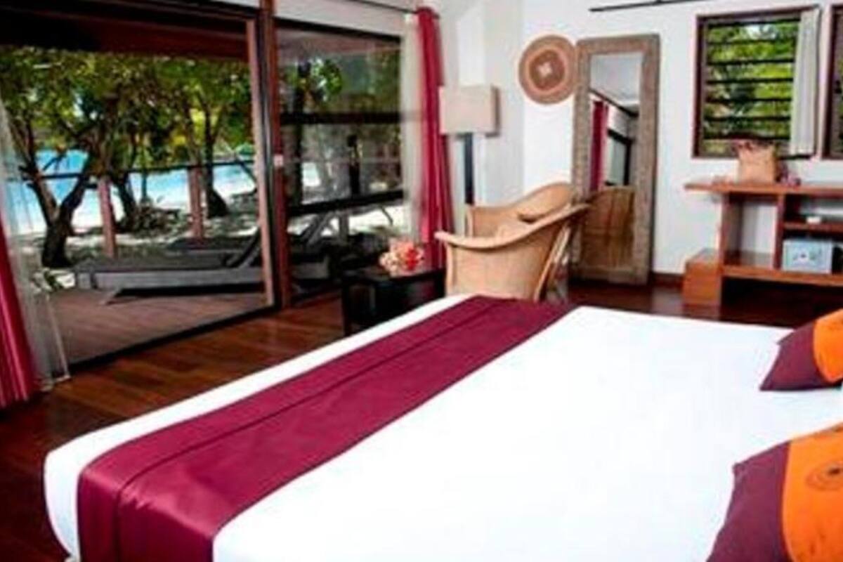 Une chambre d’hôtel avec un grand lit, un bureau, une chaise et une vue sur l’extérieur.