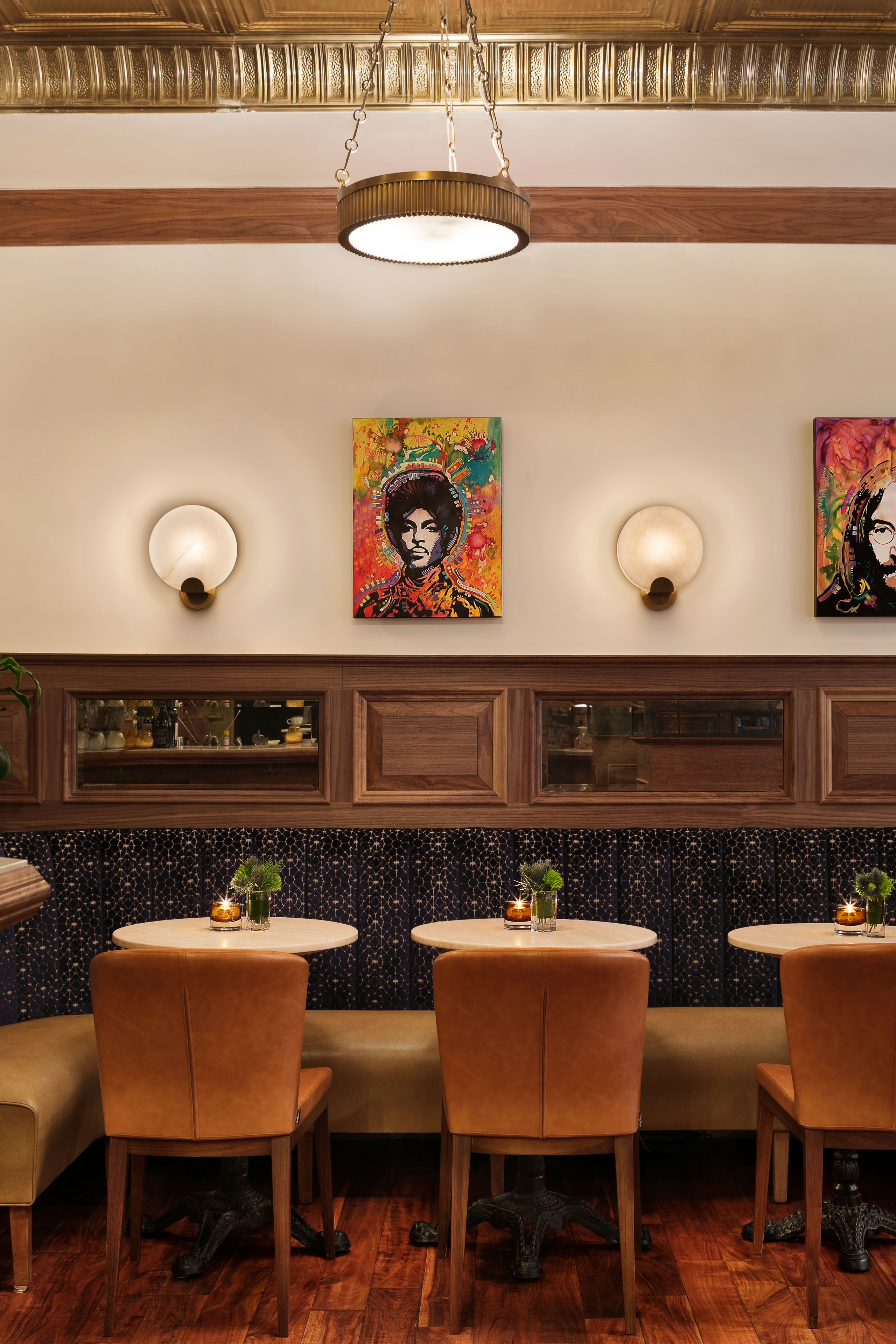 A restaurant with wooden paneling, a high ceiling, and artwork on the walls.