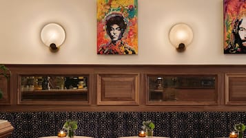 A restaurant with wooden paneling, a high ceiling, and artwork on the walls.