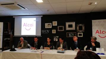 Un salón de conferencias con una mesa dispuesta para un debate.