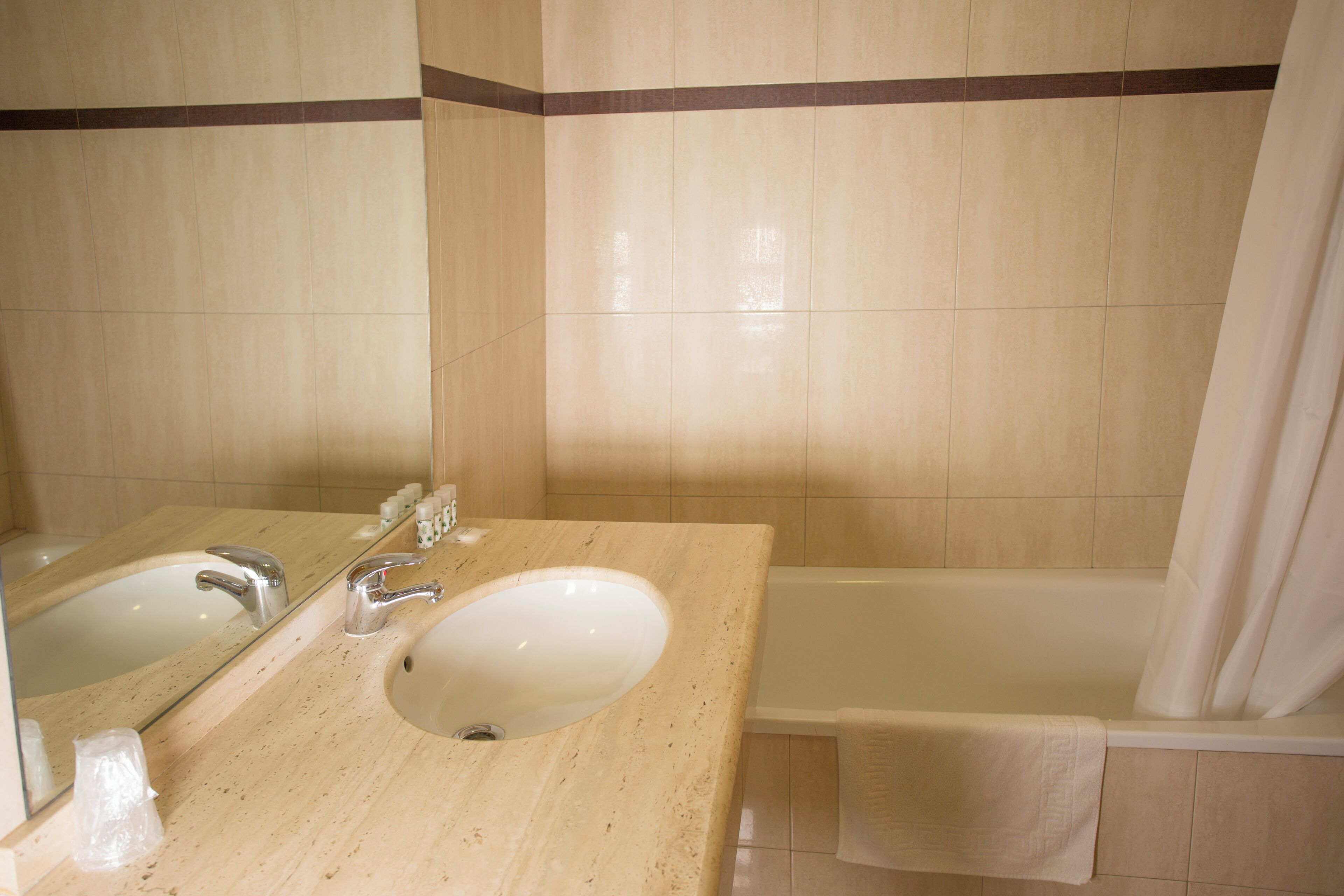 Un baño con lavabo, espejo y bañera.