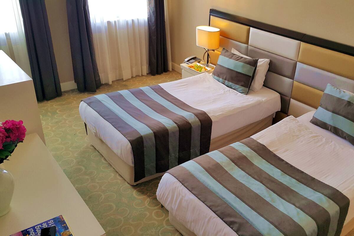 أسرّة بطبقة علوية مريحة وميني بار وخزنة داخل الغرفة