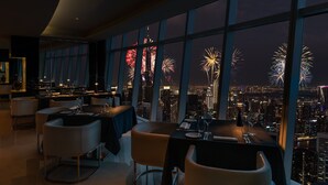 A high-rise restaurant with large windows offering a cityscape view. - JW Marriott Marquis Hotel Dubai (Dubai)