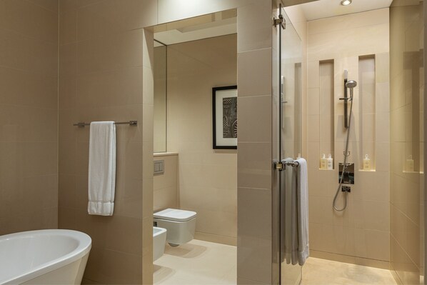 Un baño moderno con bañera, inodoro y zona de ducha.