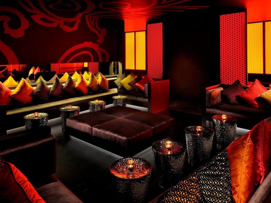 Eine schummrige Lounge mit bequemen Sitzgelegenheiten und dekorativen Kerzen.
