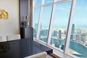 A modern dining area with a large window offering a view of a cityscape and water.