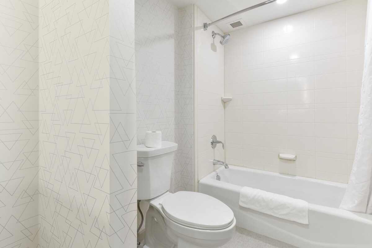 A bathroom with a toilet, a shower, and a bathtub.