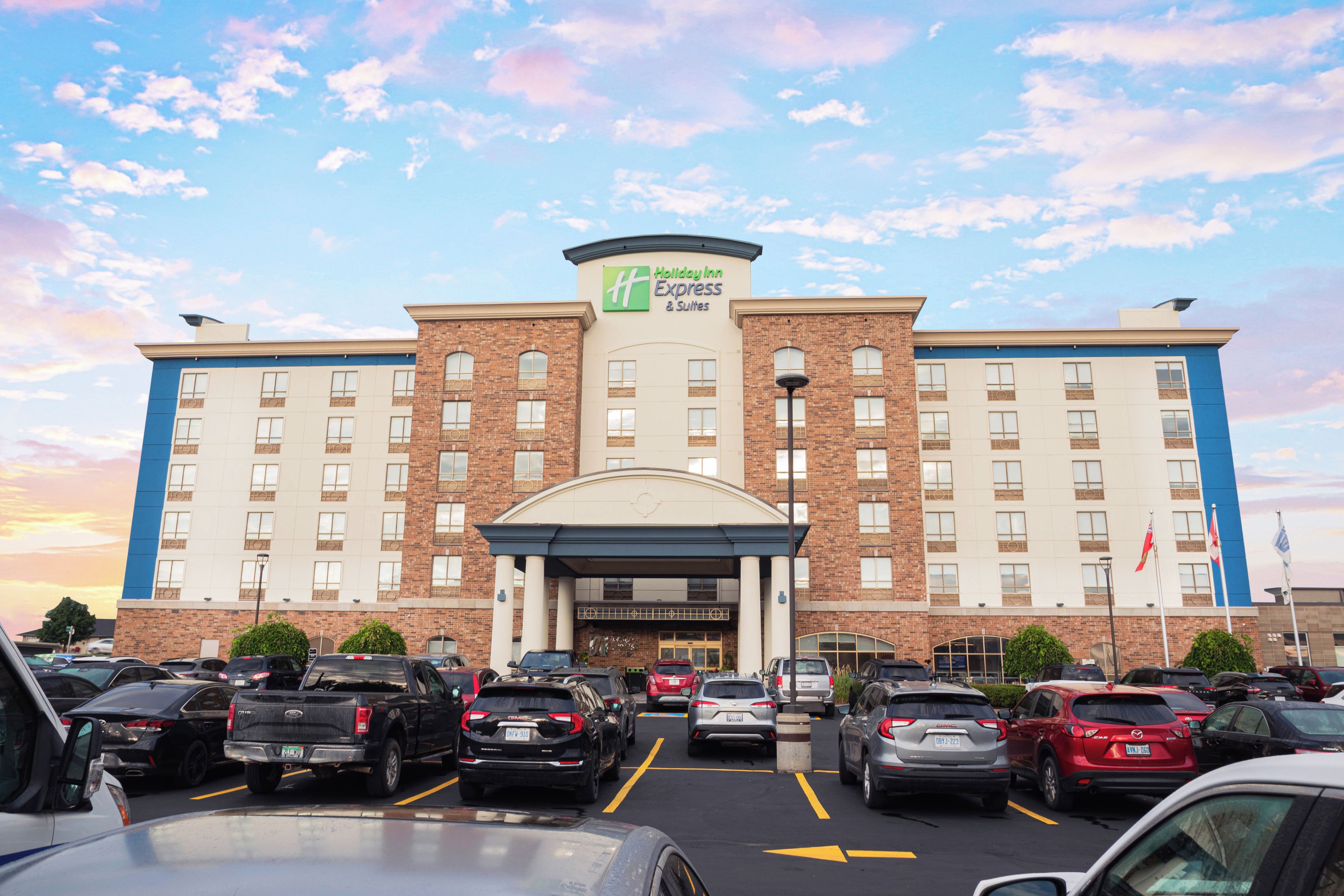 A Holiday Inn Express & Suites hotel with a parking lot full of cars.