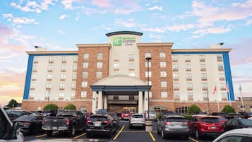 A Holiday Inn Express & Suites hotel with a parking lot full of cars.