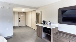 Ein Hotelzimmer mit Küchenzeile, Flachbildfernseher, Kaffeemaschine und Mikrowelle.