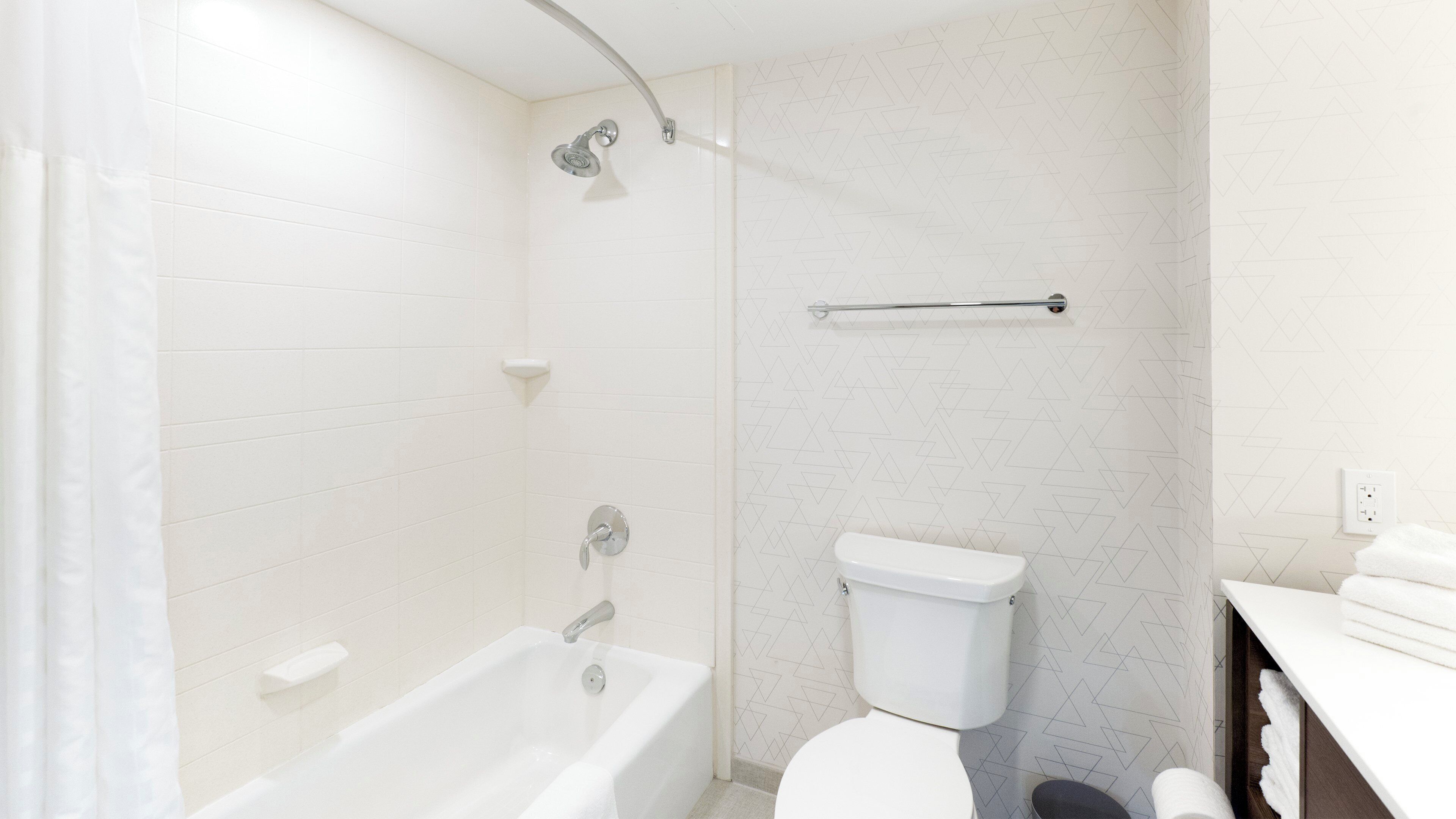 A bathroom with a bathtub, toilet, and shower.