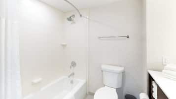 A bathroom with a bathtub, toilet, and shower.