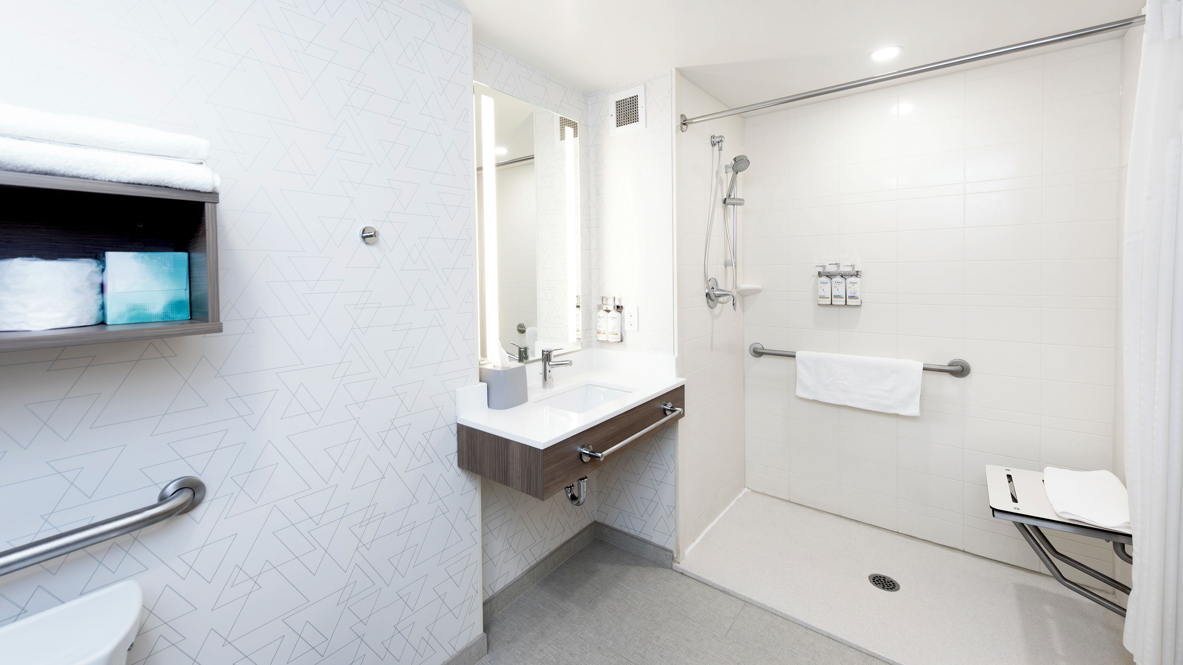 A modern bathroom with a shower, sink, and toilet.
