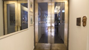 Een hotel ingang met een glazen deur en een metalen omlijsting.