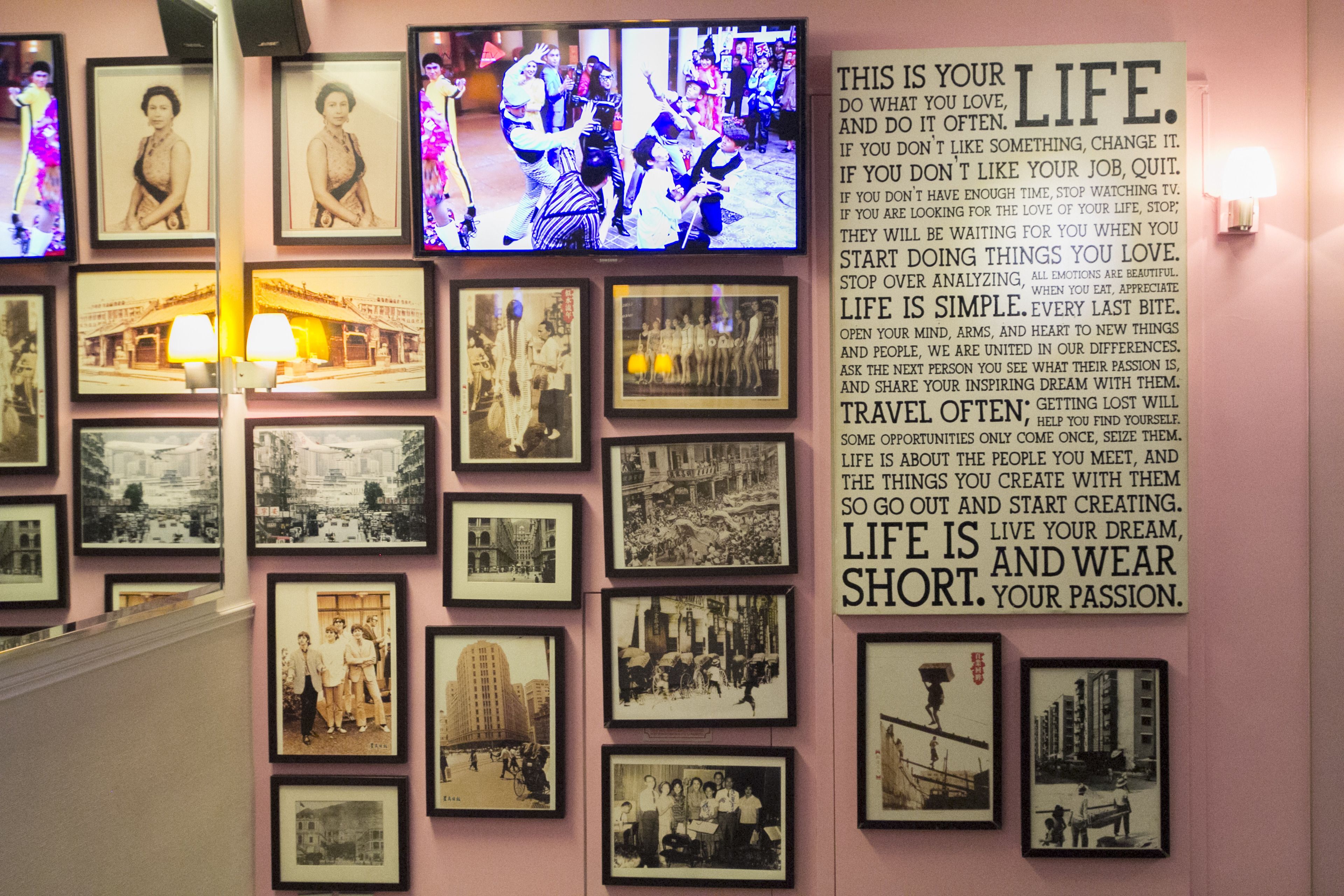 Un mur orné de photographies encadrées et d’une citation inspirante.