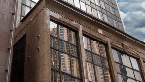 Een modern gebouw met een glazen gevel en een bakstenen fundering.