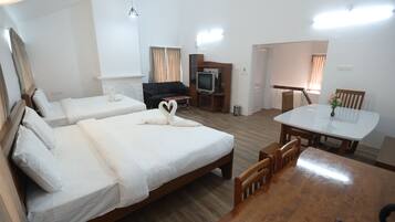 Habitación de hotel con dos camas, una mesa de comedor, televisión y una escalera.
