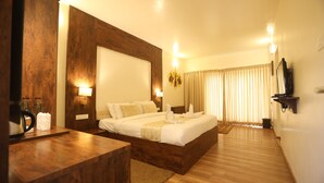 Ein Hotelzimmer mit einem großen Bett, einem Holz-Kopfteil, Nachttischen und einem wandmontierten Flachbildfernseher.