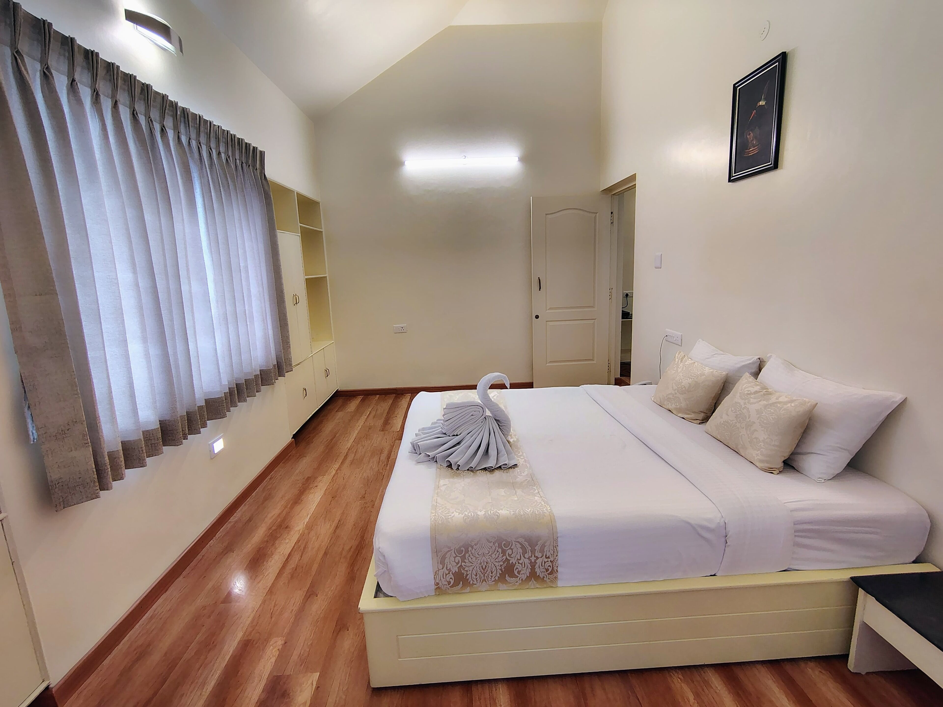 Une chambre d’hôtel avec un lit, une table de chevet, une armoire et une porte.