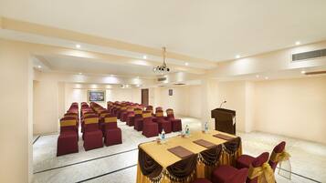 A conference room with rows of chairs, a podium, and a projector.