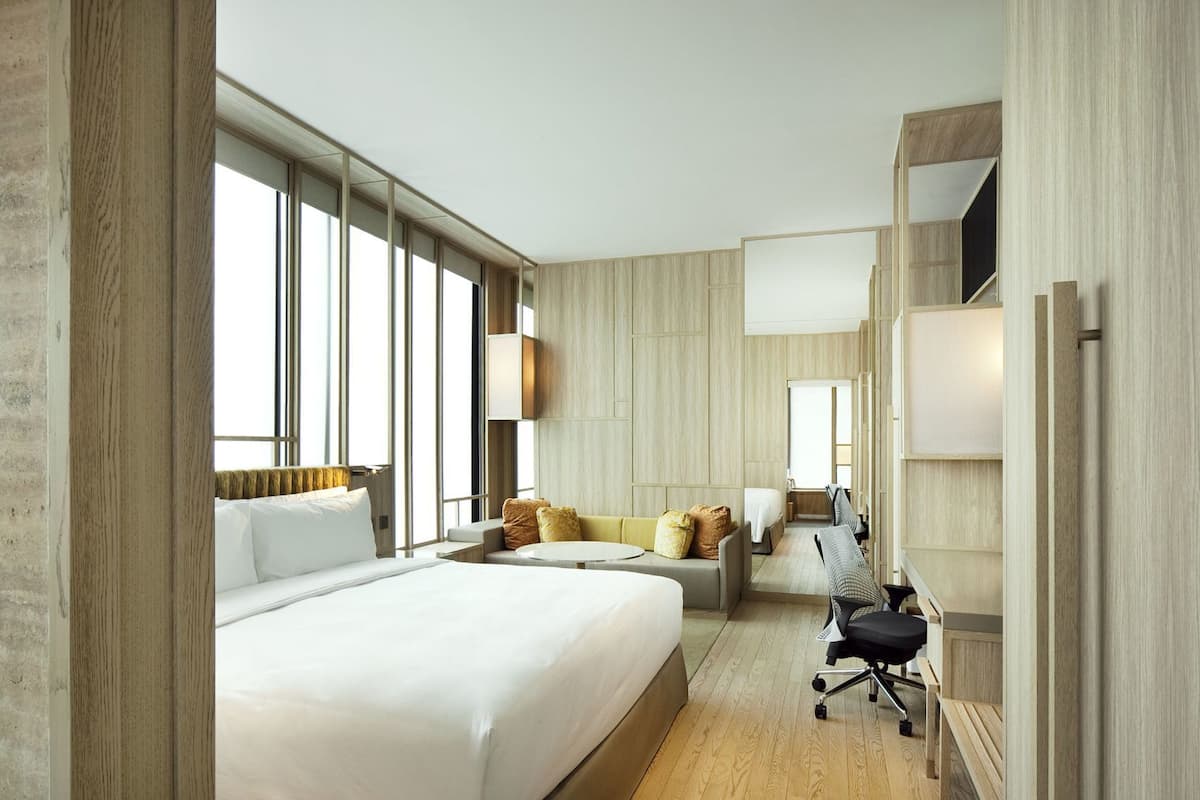 Une chambre d’hôtel moderne, dotée d’un grand lit, d’un canapé, d’un bureau et d’une chaise.