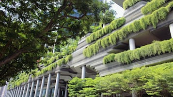 Un edificio moderno con varios pisos, cada uno con un balcón cubierto de vegetación.