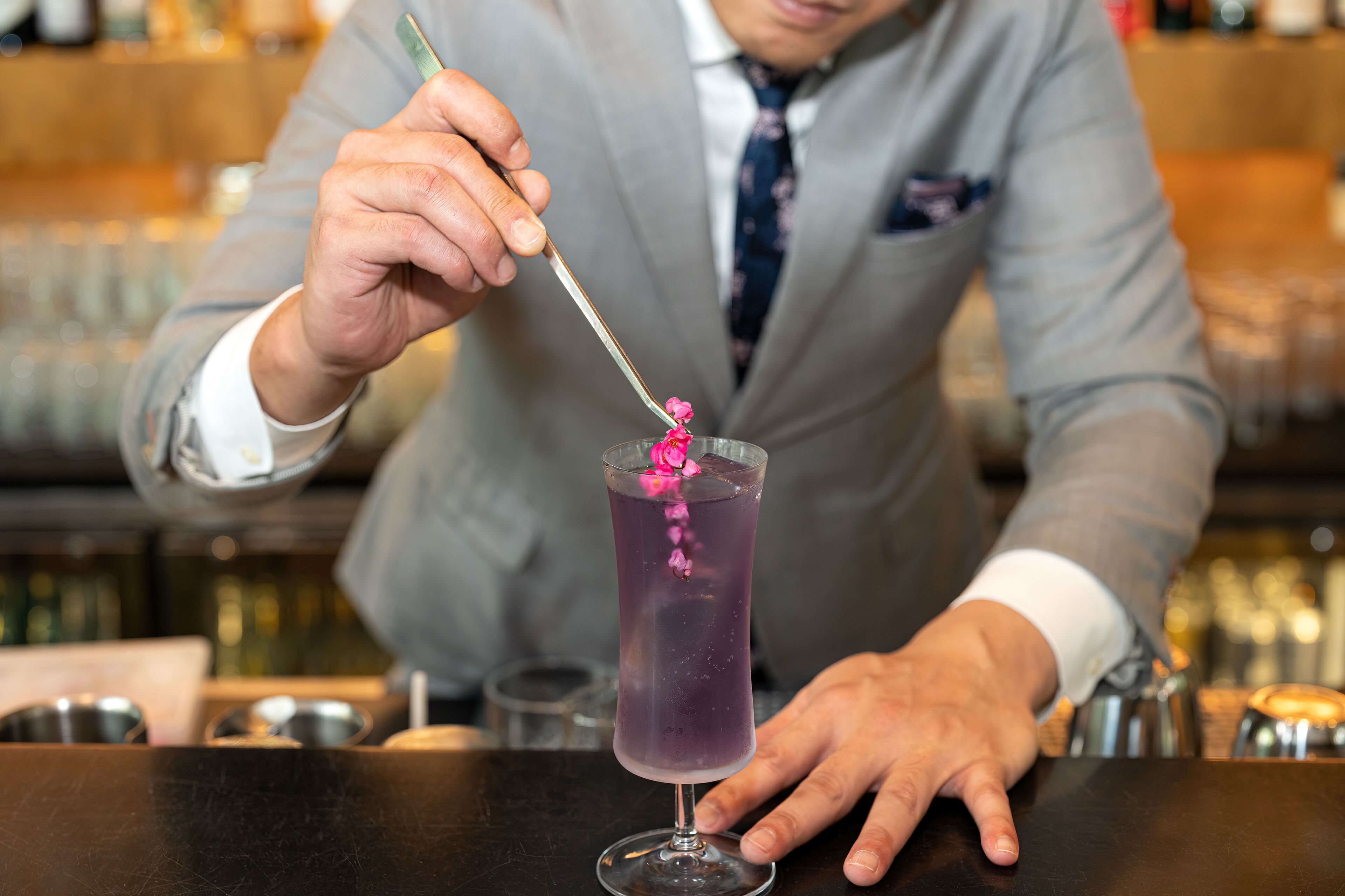 En bartender som blandar en drink med hjälp av en sked.