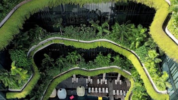 A modern building with a rooftop garden, curved pathways, and outdoor seating areas.