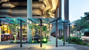 A modern building with a unique architectural design featuring curved lines and a glass canopy over an outdoor seating area.