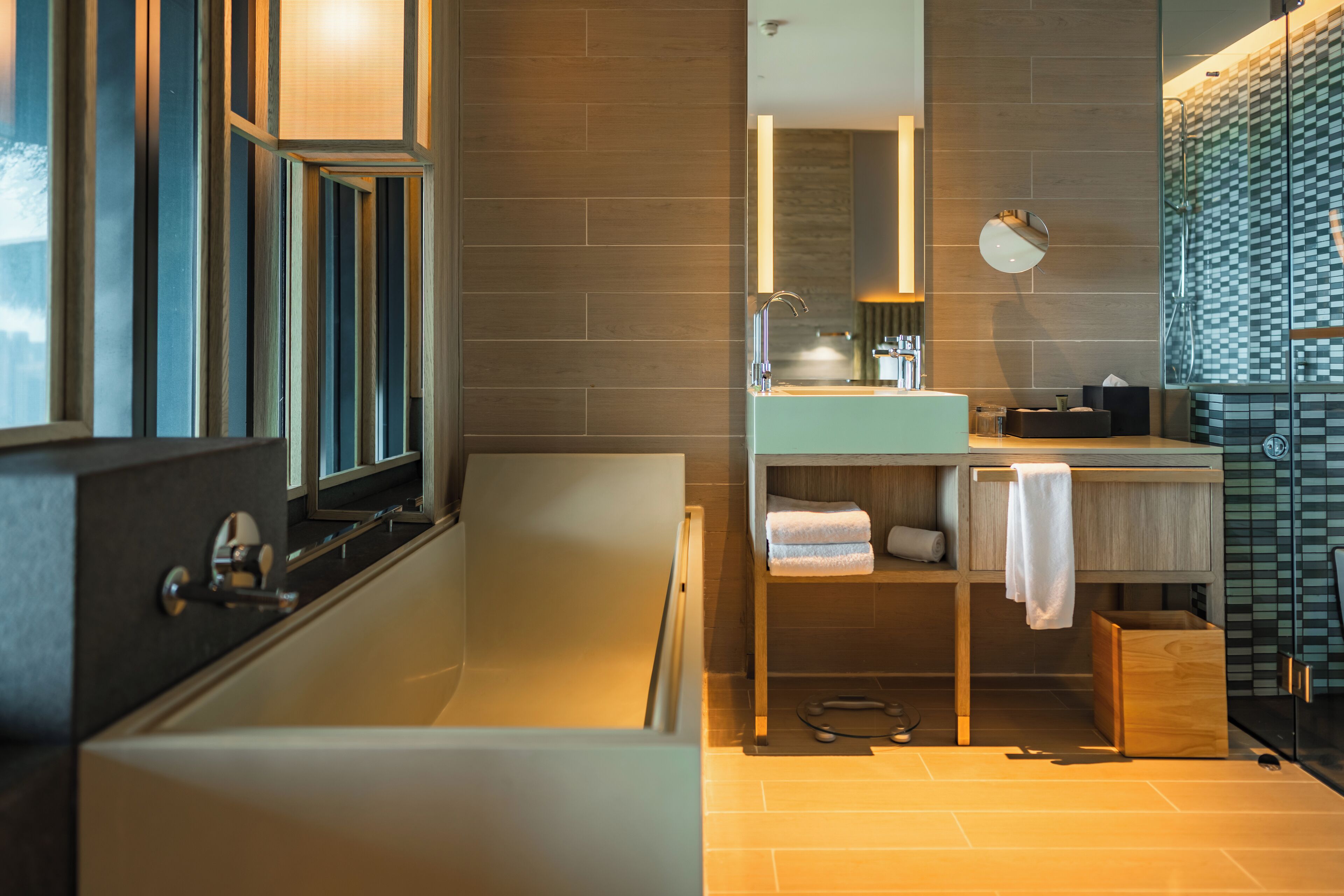 Un baño moderno con bañera, tocador con espejo y zona de ducha.