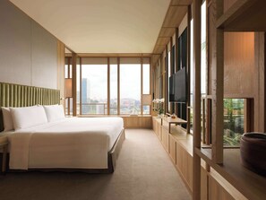 A modern hotel room with a large bed, a TV, and a view of the city. - PARKROYAL COLLECTION Pickering, Singapore (Singapore)